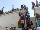  Караваны латиноамериканских мигрантов готовы штурмовать стену, построенную на границе США и Мексики 