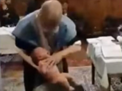 Шокирующее видео: во время крещения румынский священник жестоко обошелся с младенцами