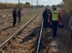 Пожилые люди пересекают железную дорогу, пробираясь под поездом, – одну из женщин сбило насмерть