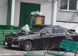 На небрежно припаркованный перед 9-этажкой советской постройки шикарный Cadillac высыпали кучу мусора