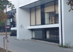 Некий кишиневский коммерсант смакует свастику на стене своего магазина