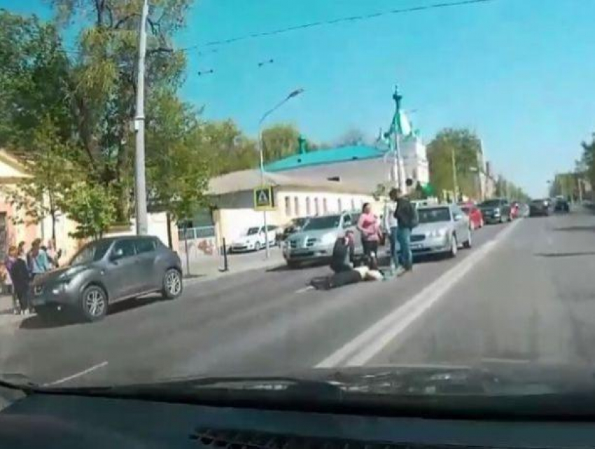 В центре города сбита женщина, люди пытаются помочь ей