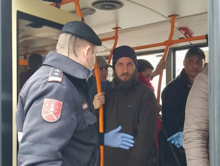 Полицейские контролируют, чтобы люди не подходили близко друг к другу в троллейбусах