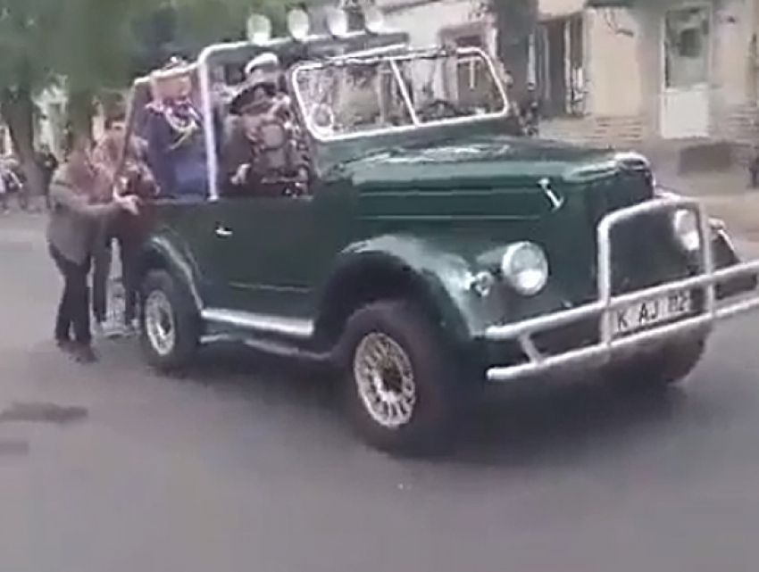 Парни дотолкали сломавшийся ретро-автомобиль с ветеранами на Марше памяти в Кишиневе 