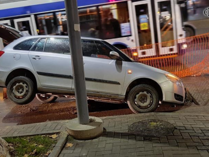 В столице автомобиль провалился в яму посреди дороги