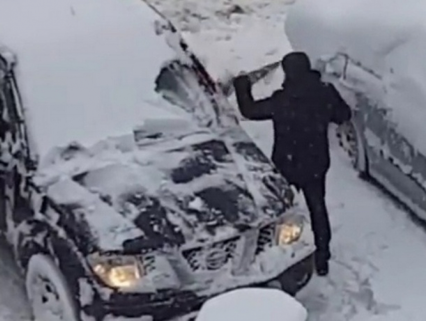 Мужчина с пилой набросился на свой заснеженный автомобиль на улице Кишинева